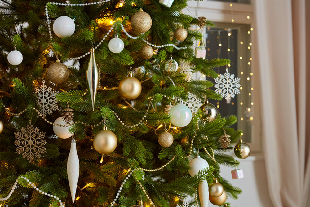 Ziemassvētku eglīte ar rotājumiem zelta, sudraba un baltā krāsā.