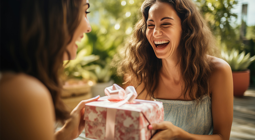 Smaidoša sieviete pasniedz dāvanu draugam.