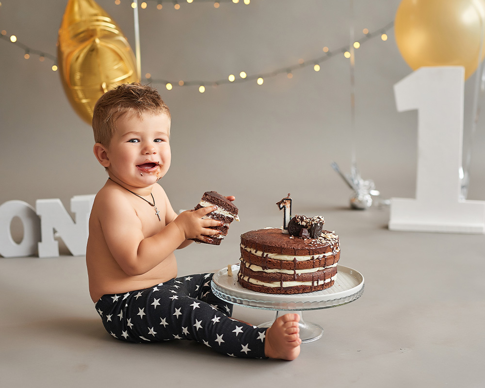 Gadu vecs zēns savā dzimšanas dienā tur rokās šokolādes kūkas gabalu